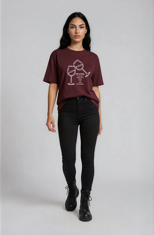 Person wearing a burgundy t-shirt with a graphic design on a plain background