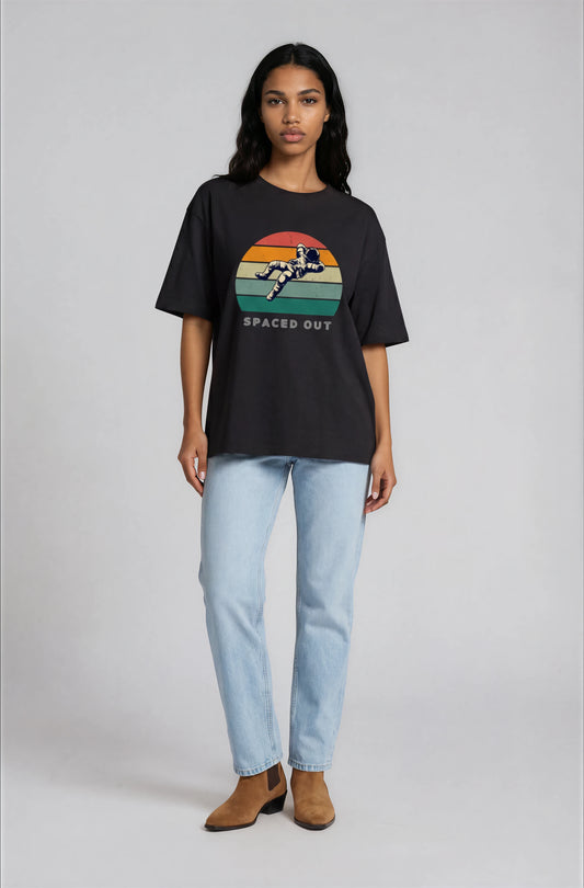 Person wearing a black t-shirt with a colorful graphic and text, standing against a plain background